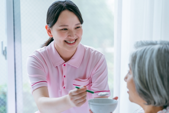 食事介助する女性介護士